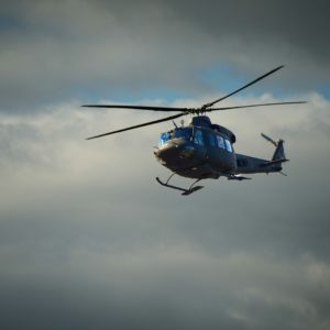 A military helicopter flying in a cloudy sky