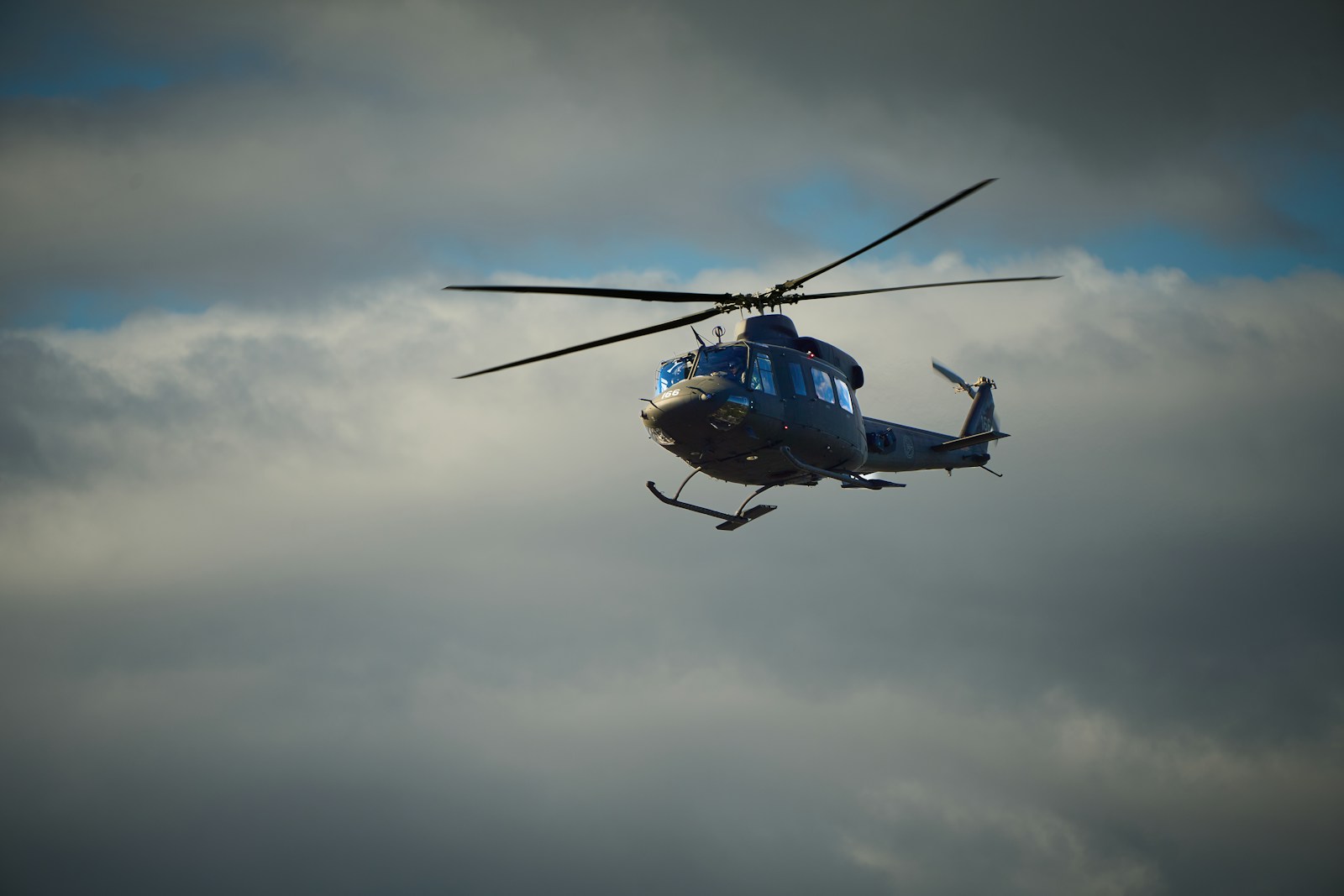 A military helicopter flying in a cloudy sky